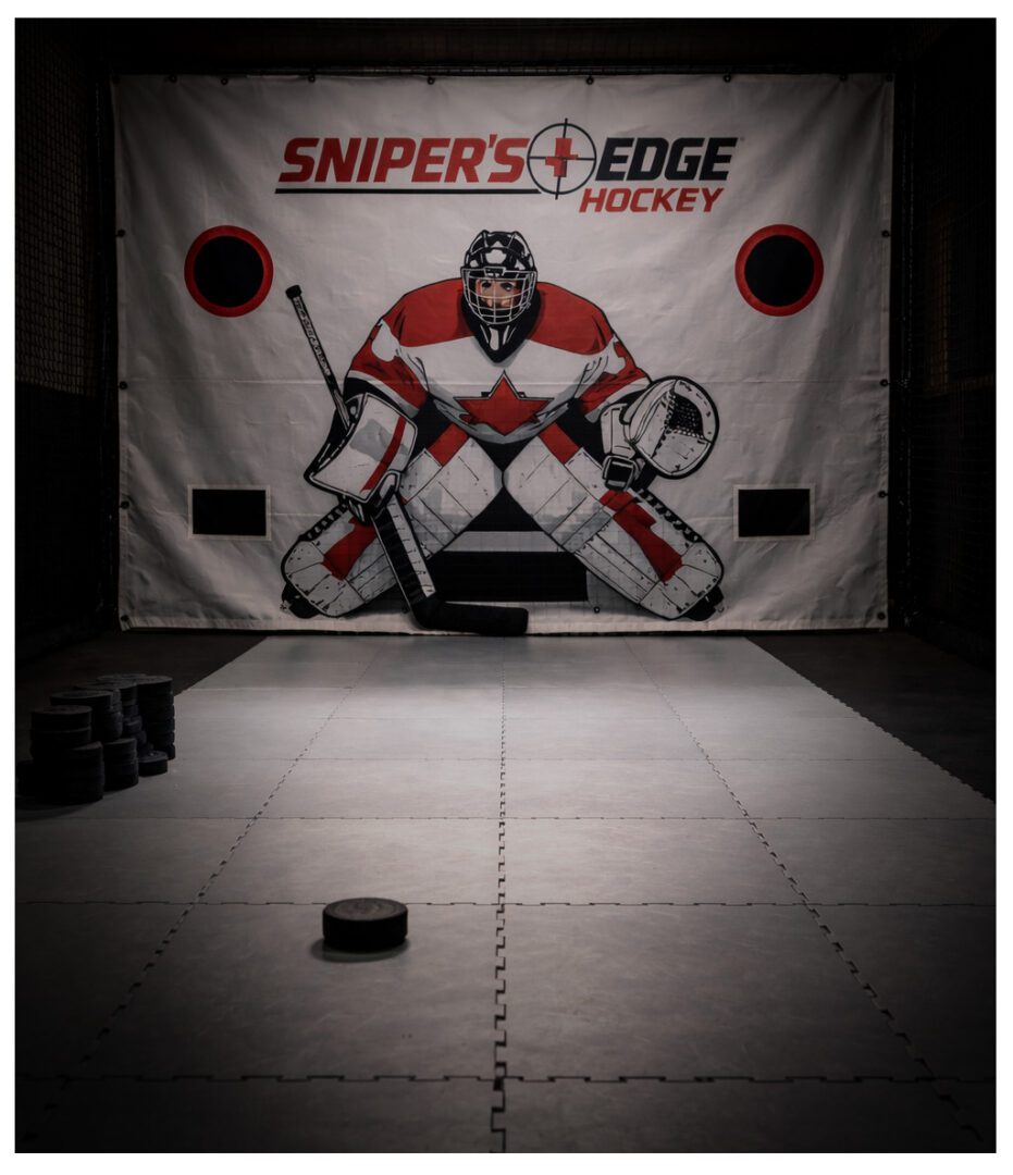 A hockey puck on the ice facing a goalie target board.